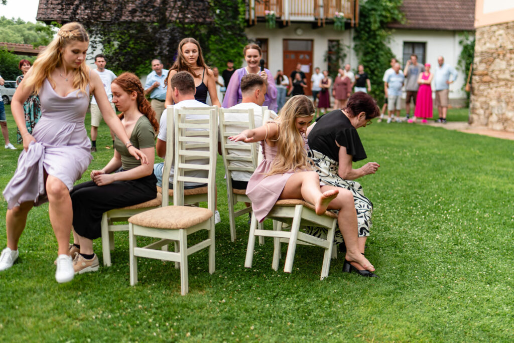 Hosté hrají svatební hru se židlemi během zábavy na venkovní svatbě